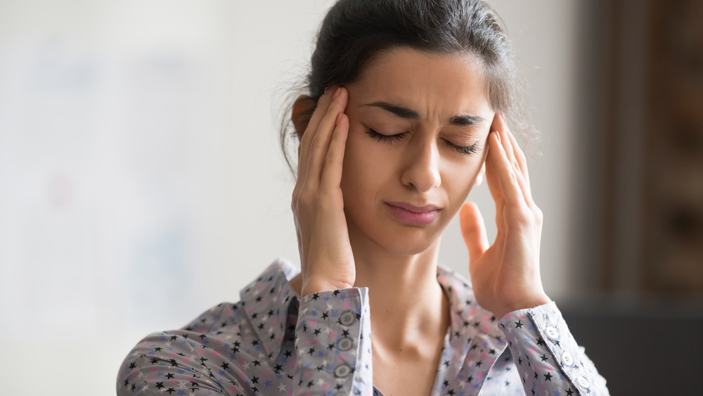 Woman with hands on her temples