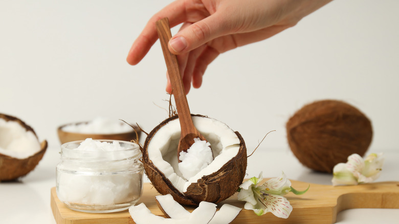 woman's hand scooping coconut meat out of shell