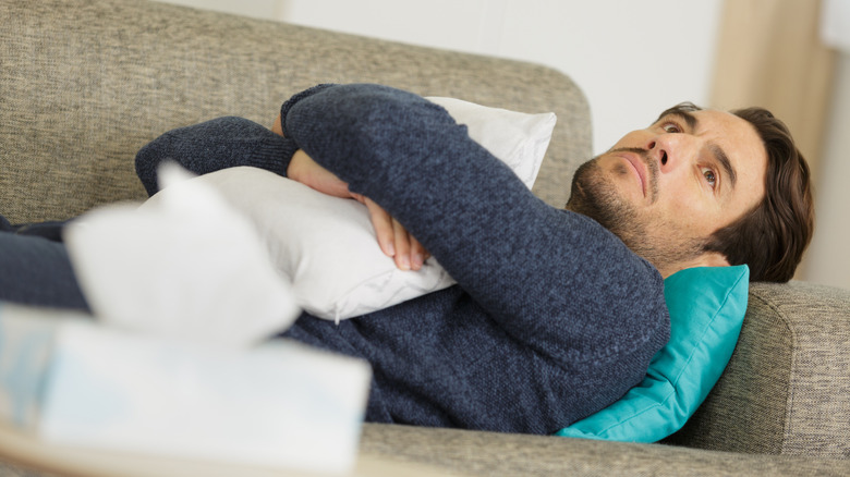 a man lays depressed on the couch 