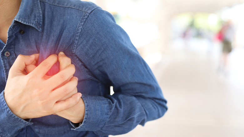 Man holding his hands over his heart as if he is in pain