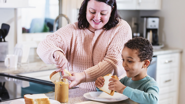 Smiling mom and son making PB&J