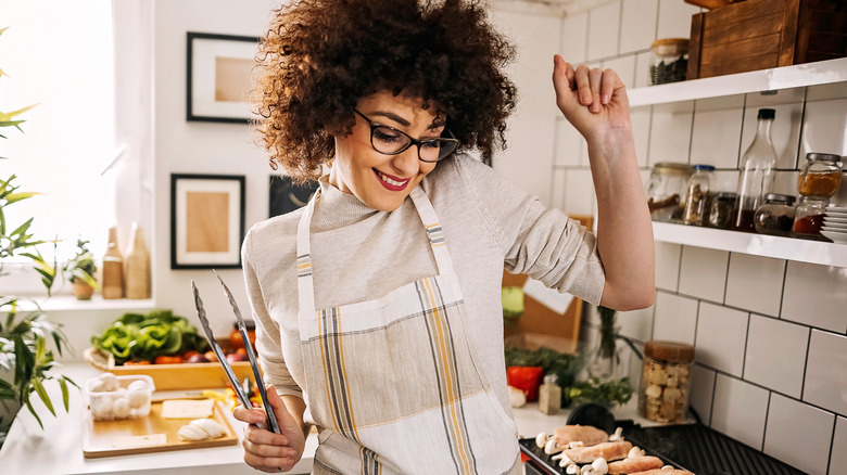 Smiling woman dancing in kitchen