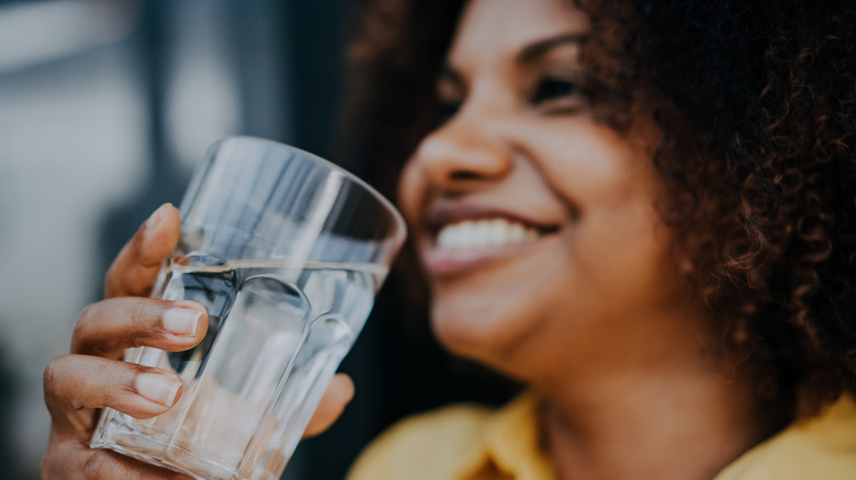 Smiling woman holding glass of water