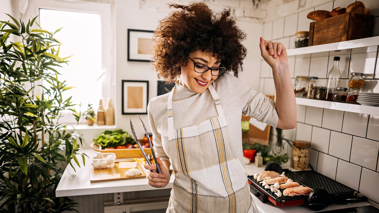 Smiling woman dancing in kitchen
