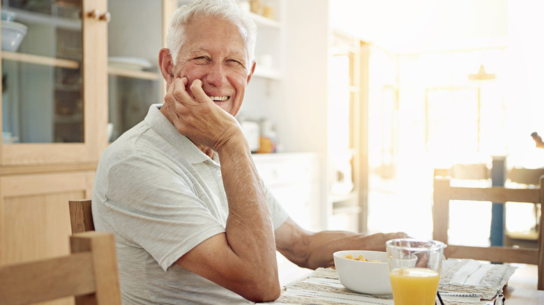 A happy older man eating a healthy breakfast