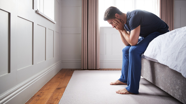 sad man sitting on bed