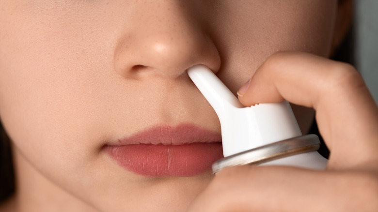 Woman administering nasal spray
