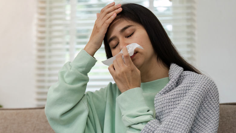 young woman feeling sick at home on sofa