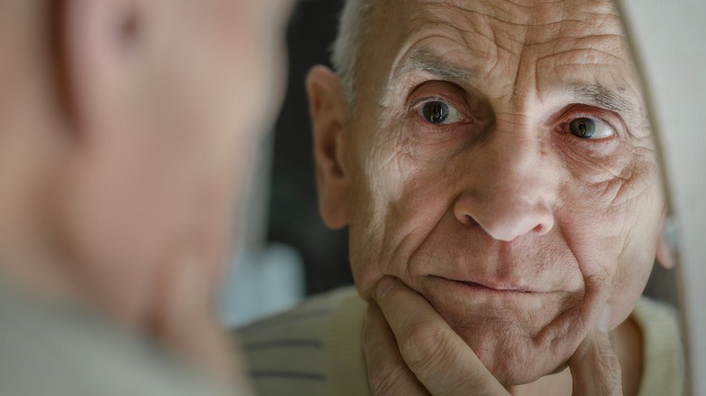 Elderly man looking in mirror