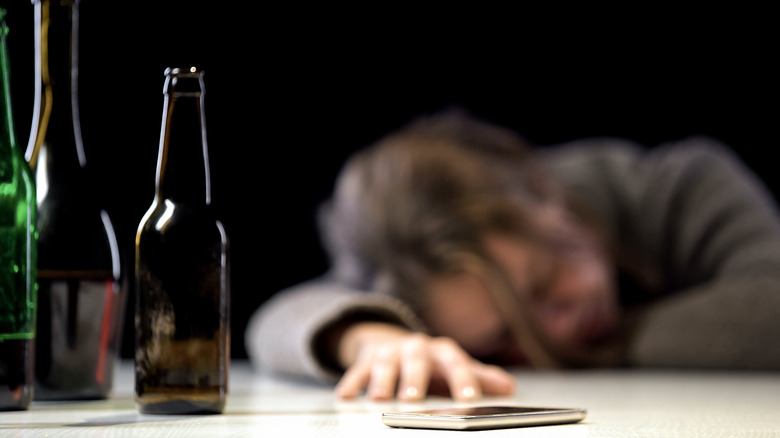 Woman with alcohol poisoning sleeping near phone