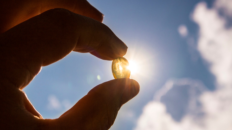 hand holding vitamin D capsule