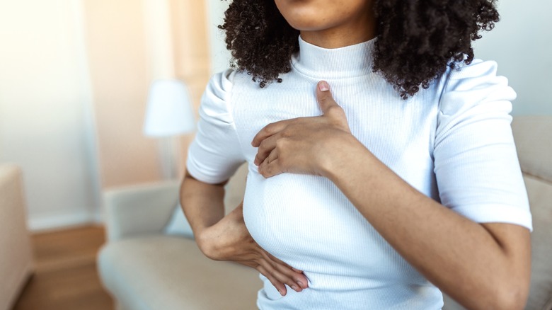 A woman performing a self breast exam