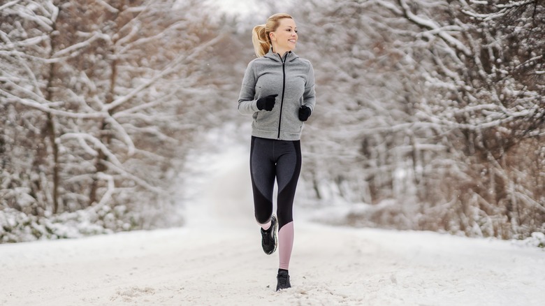 woman running happily in the snow