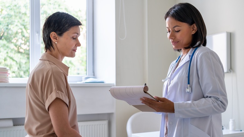 Woman speaking with smiling doctor