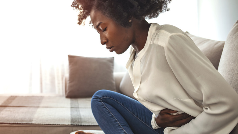 Woman holding stomach in pain