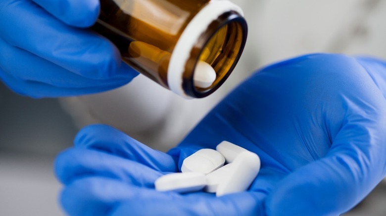 medical worker pours pill bottle