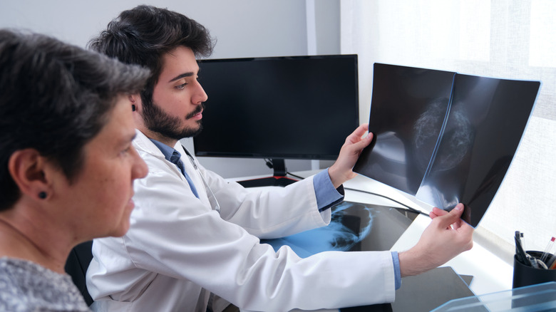 Patient and doctor examining mammogram scan