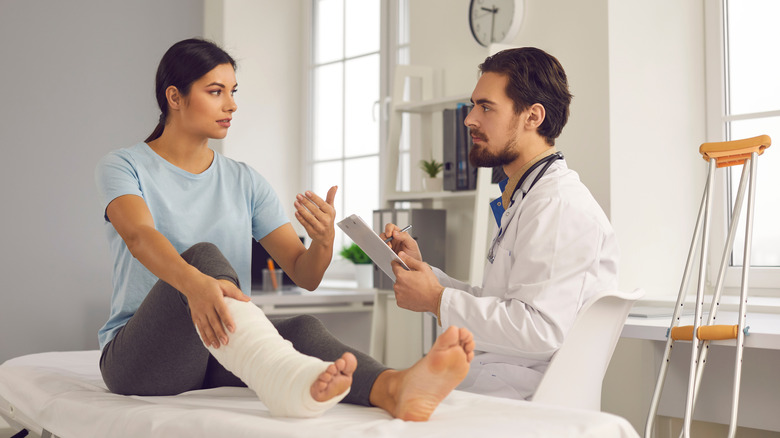orthopedist talking to patient with a foot cast