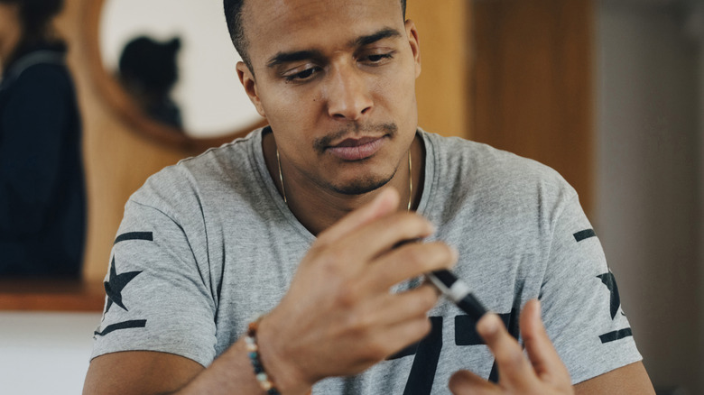 man testing blood sugar at home
