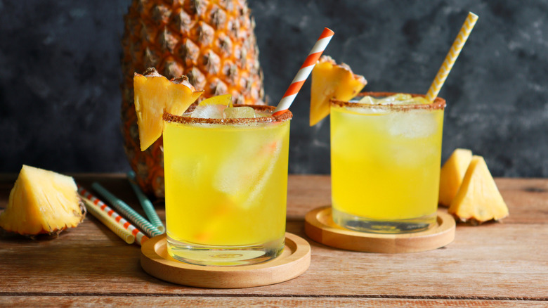 glasses of pineapple juice and a whole pineapple