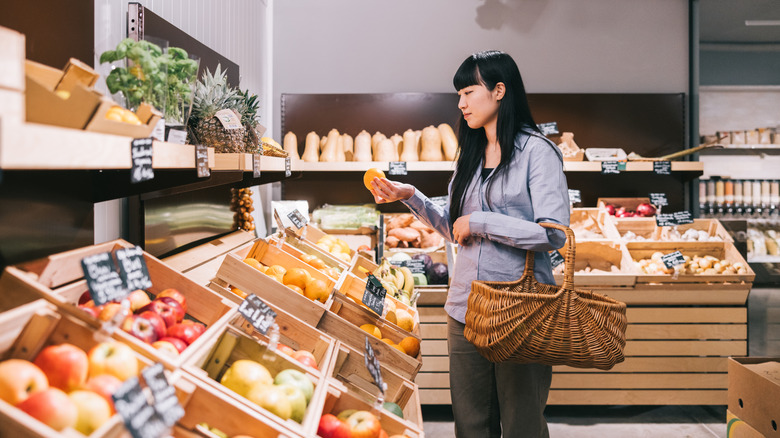A woman shopping for fruit in a produce section