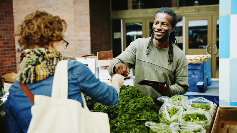 mature woman shopping for leafy greens at market