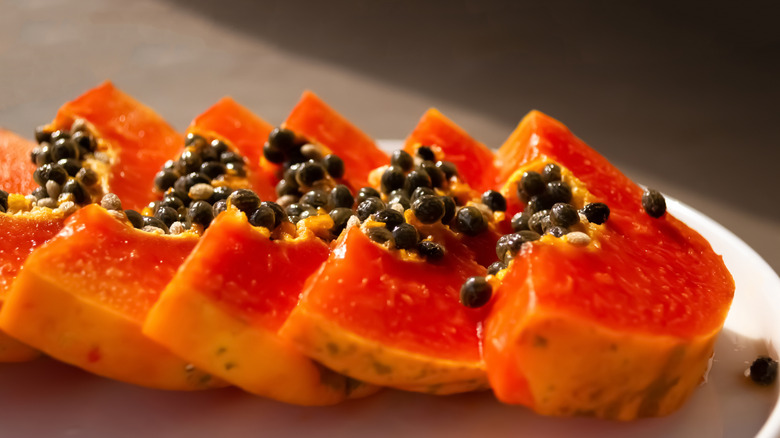 Slices of papaya fruit on a white plate