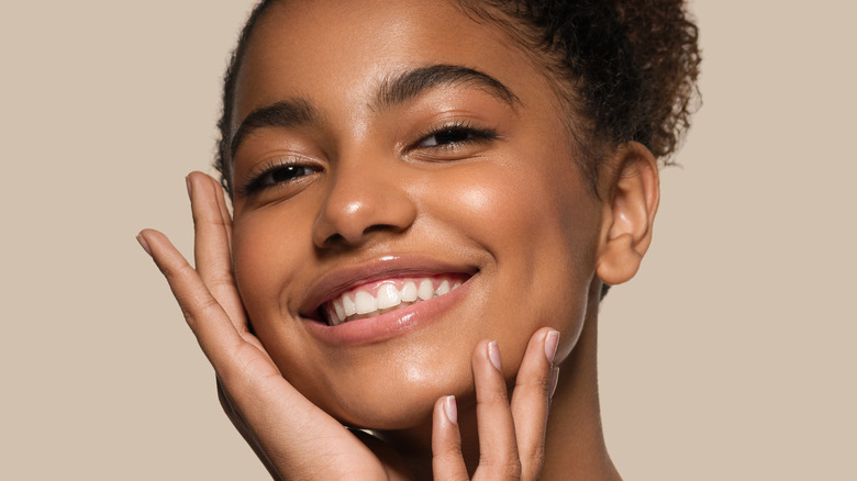 happy woman touching face