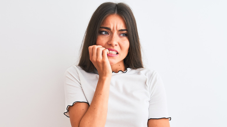 Woman biting nails suffering from anxiety