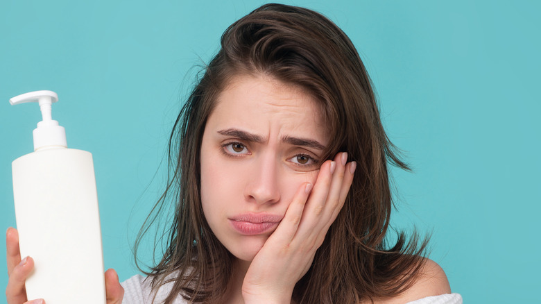 Woman holding 2-in-1 shampoo and conditioner