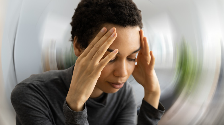 woman holding head feeling dizzy