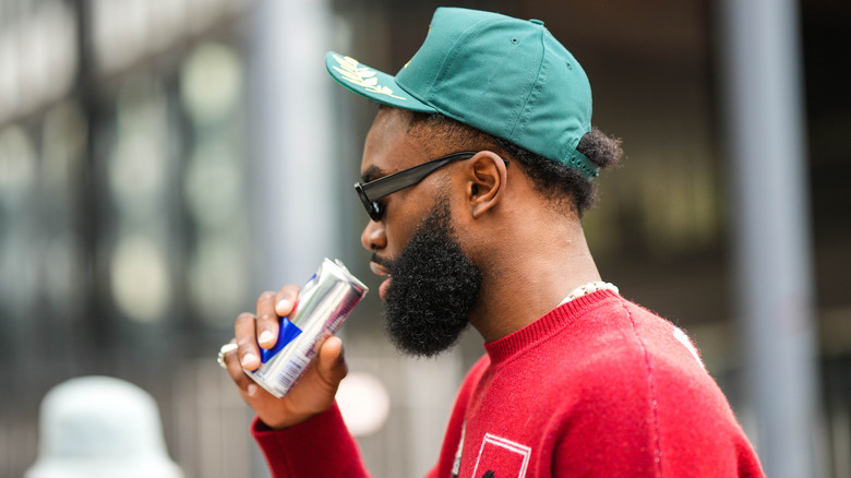 A man drinking Red Bull.