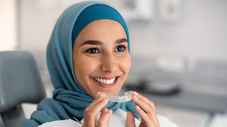 Woman holding teeth aligner