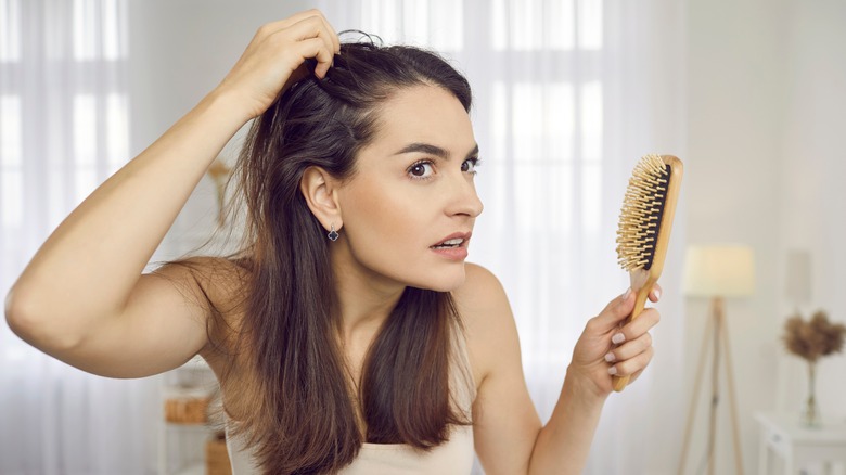 Woman looking in the mirror at hair