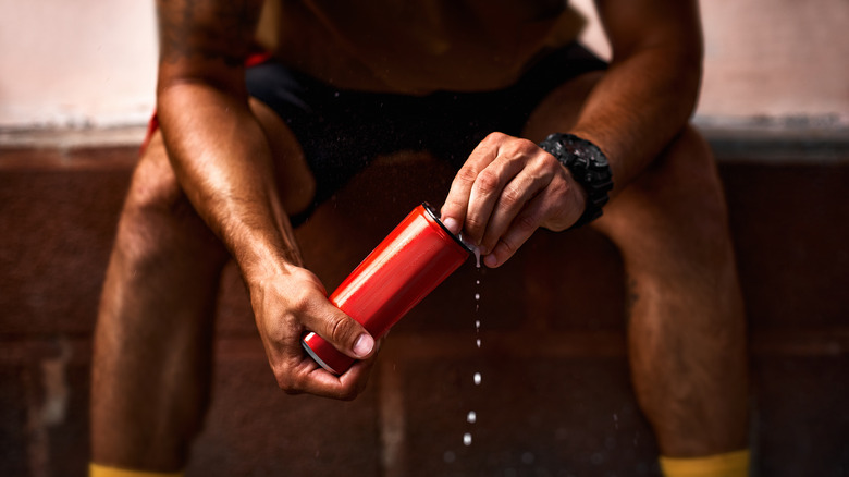 Man holds red canned energy drink