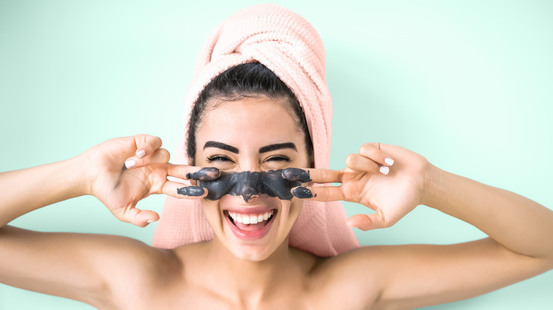 Smiling woman with charcoal mask