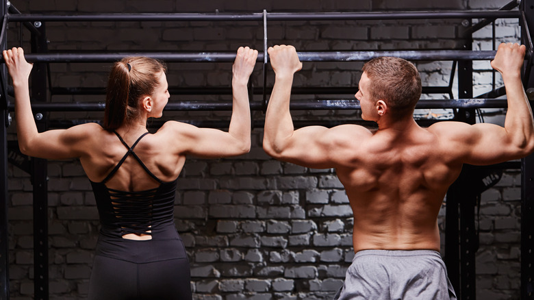 man and woman doing pull-ups