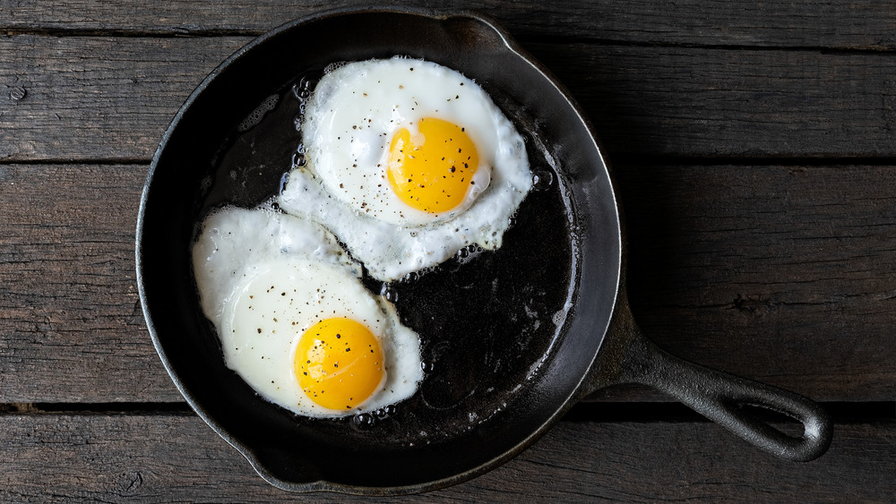 Two fried eggs in a cast iron skillet