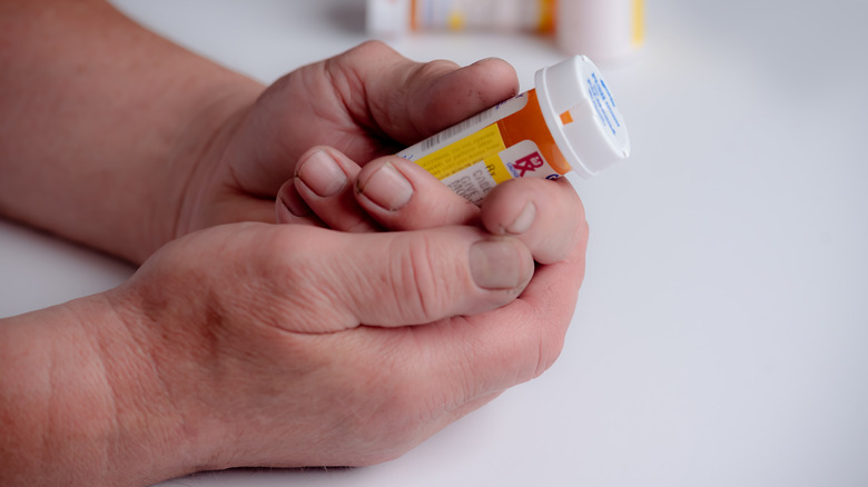 hands holding prescription drug bottle