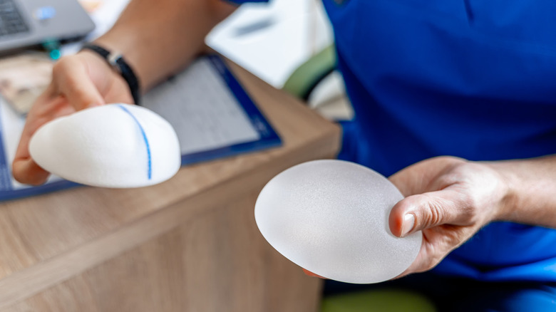Physician hands holding breast implants