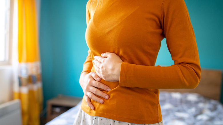 woman with motility disorder holding stomach