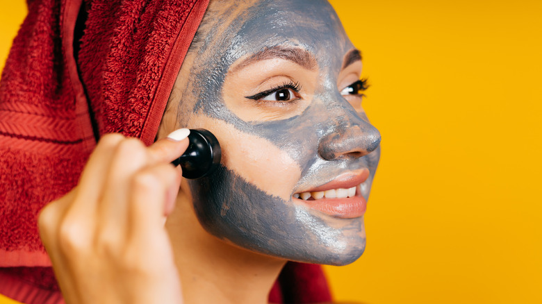 woman removing charcoal mask