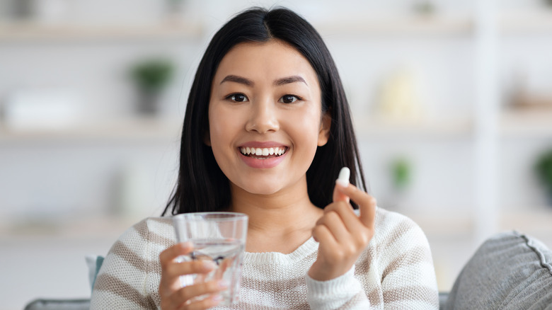 A woman takes a multivitamin