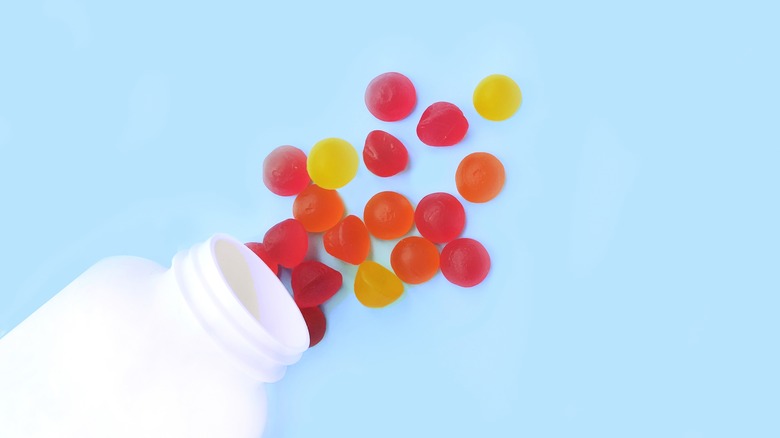 scattered gummy vitamins on blue background