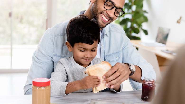 boy eating peanut butter and jelly sandwich