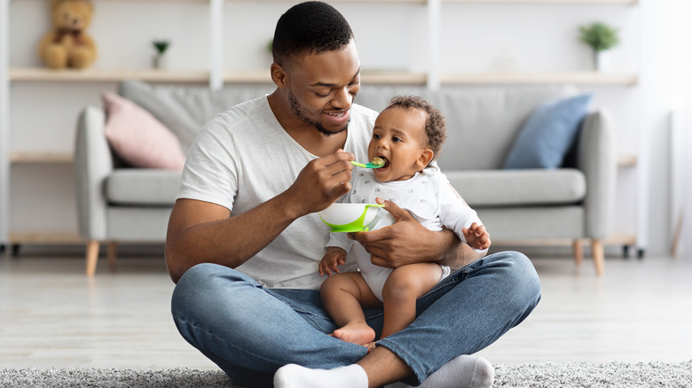 a dad feeding his baby