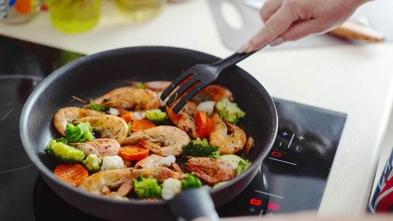 woman cooking with plastic utensil