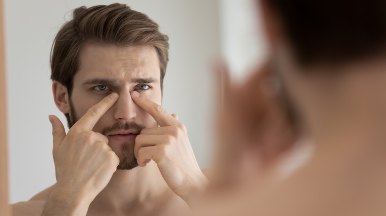 A man looks at the pores on his face