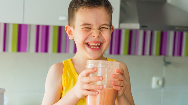 Laughing child drinking smoothie