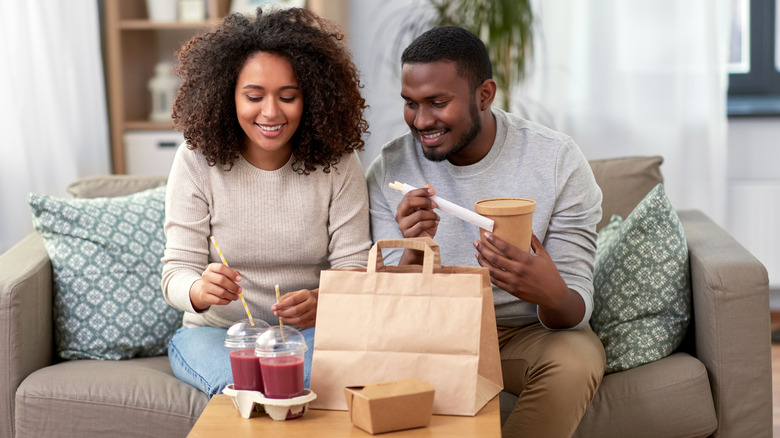 Couple with smoothies and takeout food 